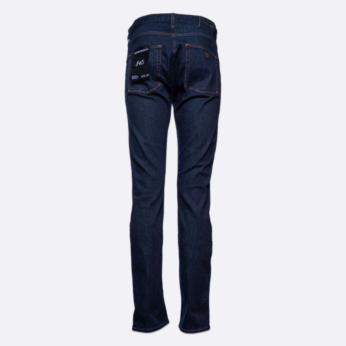 Back view of dark blue denim jeans on a light gray background, showing the back pockets with white branding and a small red tab. Emporio Armani Jeans. Sakks Menswear Southampton.