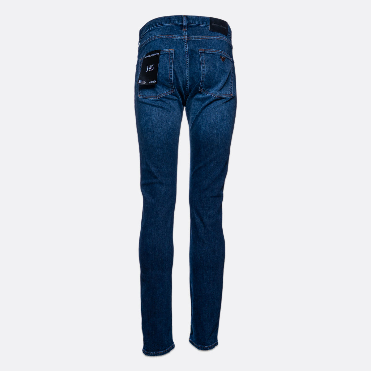 Back view of a pair of slim-fit blue jeans on a light gray background, showing the back pockets and a black brand patch on the right pocket. Emporio Armani Jeans. Sakks Menswear Southampton.