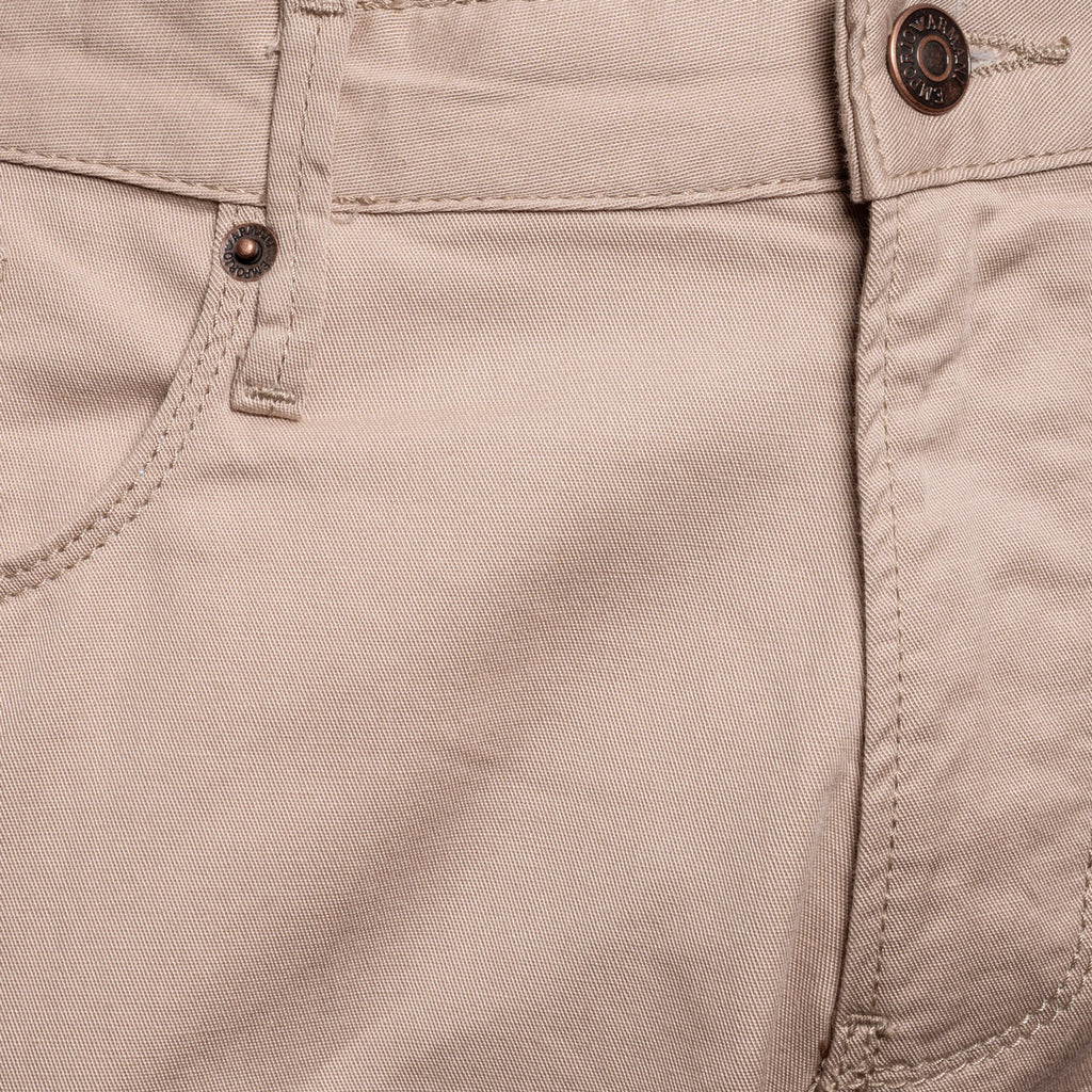 Close-up of a pair of light beige canvas pants showing the waistband, button, belt loop, and pocket stitching. Emporio Armani Chinos. Sakks Menswear Southampton.