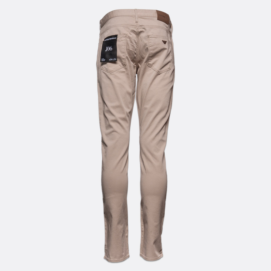 A pair of slim-fit beige trousers shown from the back, featuring a brown leather waistband patch and a black brand label on the right pocket, set against a plain light gray background. Emporio Armani Chinos. Sakks Menswear Southampton.