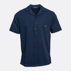 A navy blue short-sleeve button-up shirt with a camp collar, featuring a left chest pocket with a small embroidered logo and a subtle textured weave, shown on a light gray background. Emporio Armani Short Sleeve Shirt. Sakks Menswear Southampton.