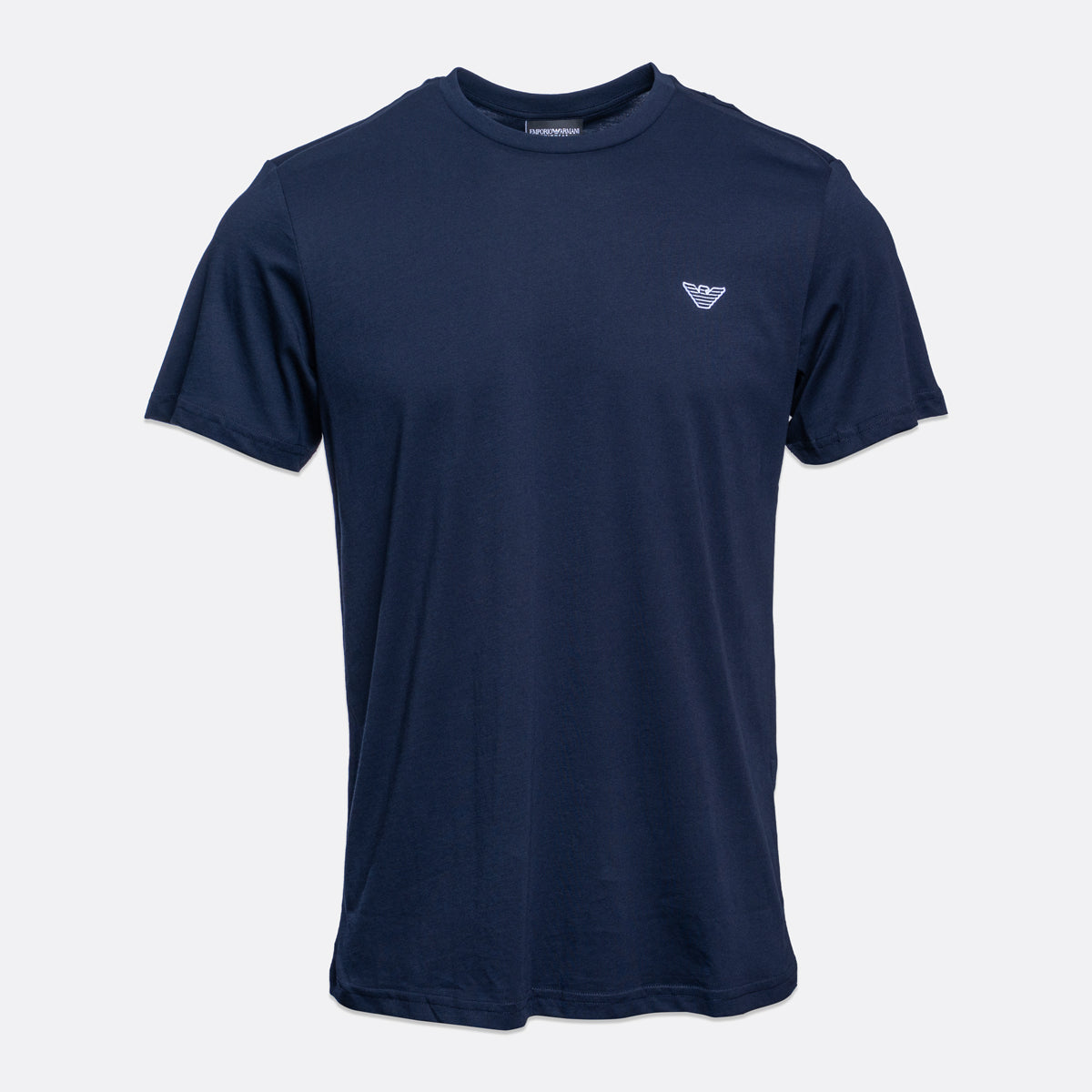 A navy blue short-sleeve crewneck t-shirt with a small white embroidered Emporio Armani logo on the left chest, displayed against a light gray background. Emporio Armani T-Shirt. Sakks Menswear Southampton.