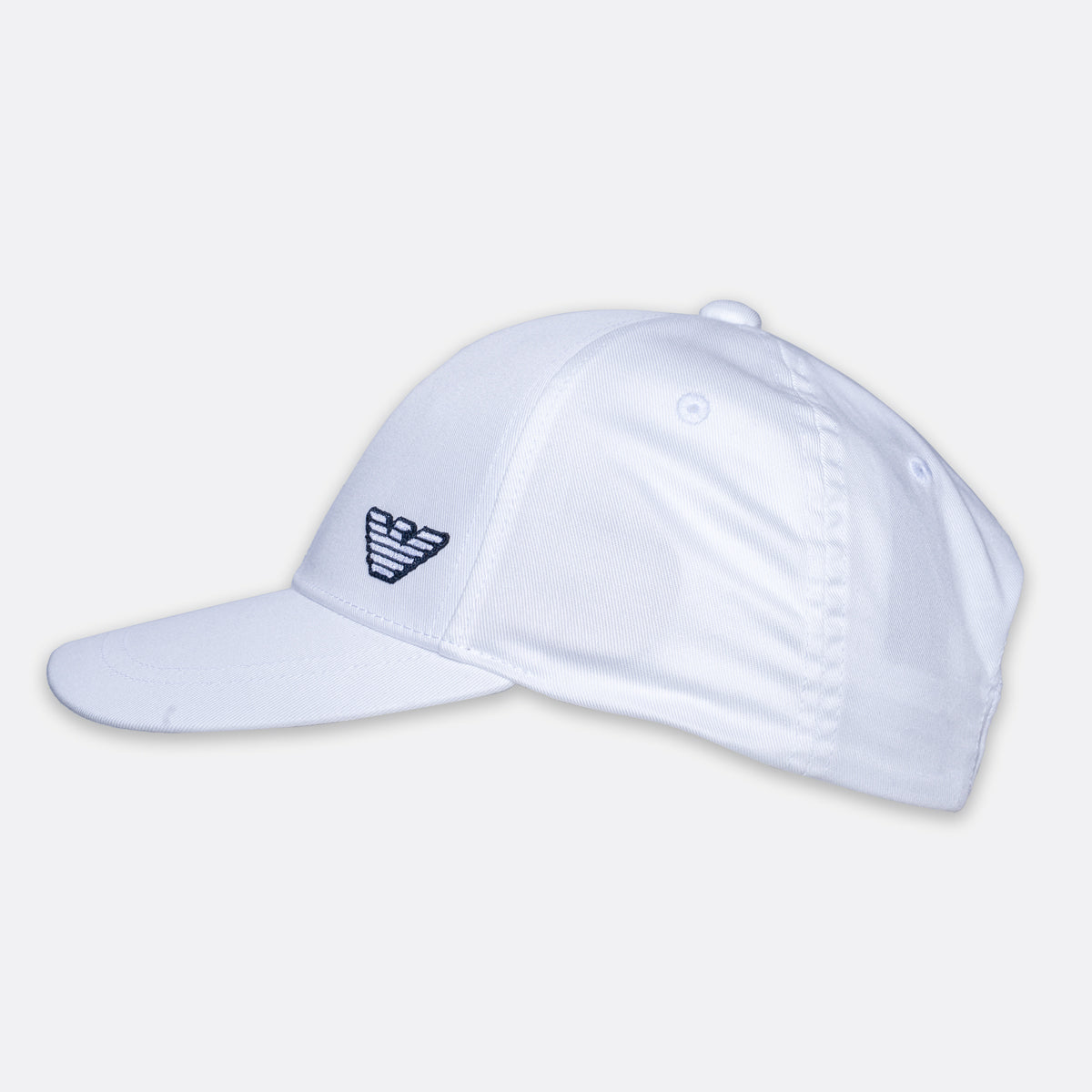 A white baseball cap with a curved brim, featuring a small dark embroidered logo on the side, shown against a light gray background. Emporio Armani Cap. Sakks Menswear Southampton.