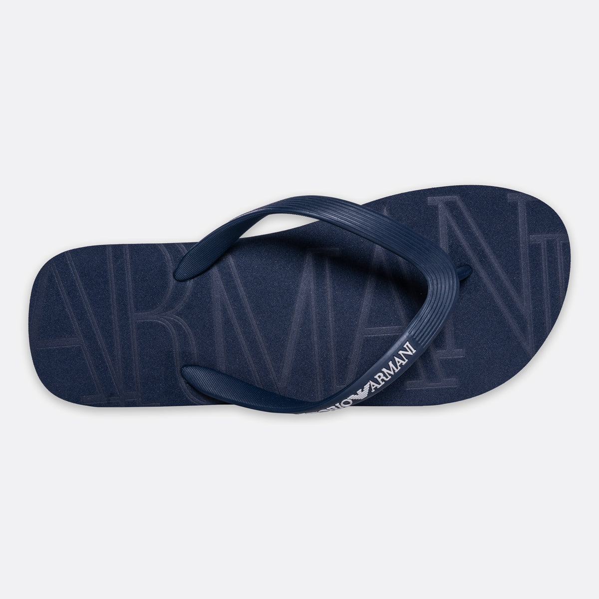A single navy blue Armani Exchange flip-flop sandal shown from a top-down view on a light gray background. Emporio Armani Flip Flops. Sakks Menswear Southampton.