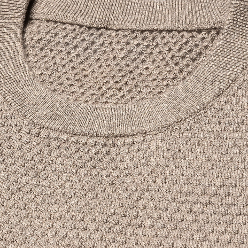 Close-up of a textured knit crewneck sweater in a warm taupe-beige color, showing the ribbed collar and waffle-knit fabric. Eton Knitwear available at Sakks Menswear in Southampton.