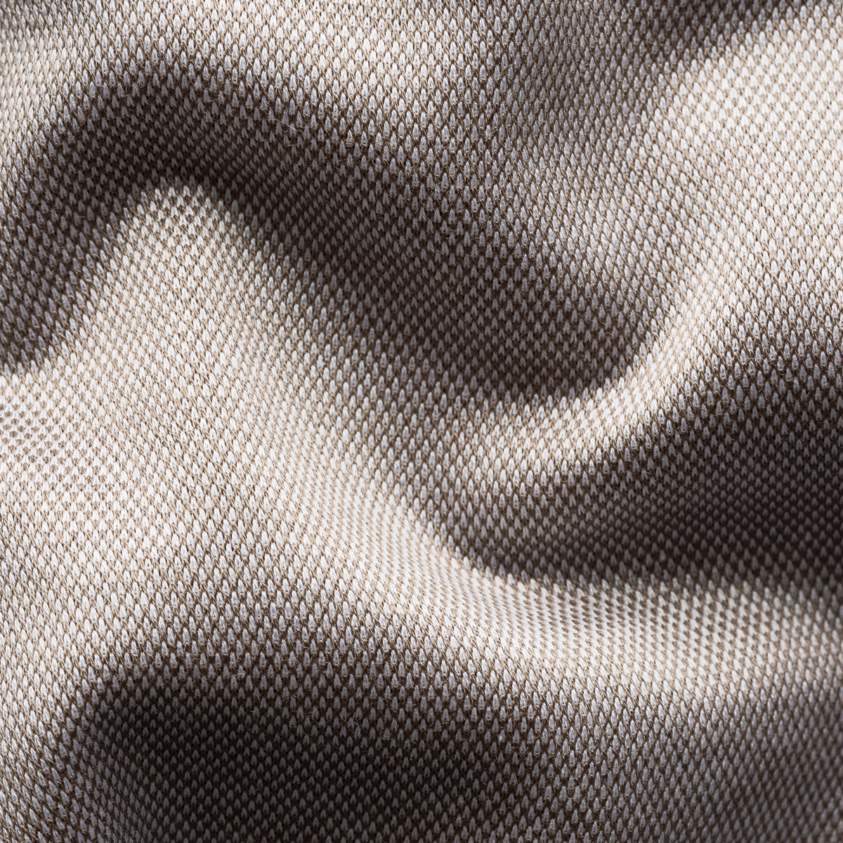 Close-up of a textured woven fabric with a fine mesh-like pattern, shown in soft folds with a colour gradient from light taupe to dark grey. Eton Shirt available at Sakks Menswear in Southampton.