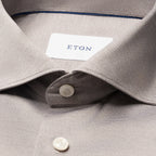Close-up of a light grey micro-check dress shirt with a white collar label reading ETON and white buttons. Eton Shirt available at Sakks Menswear in Southampton.