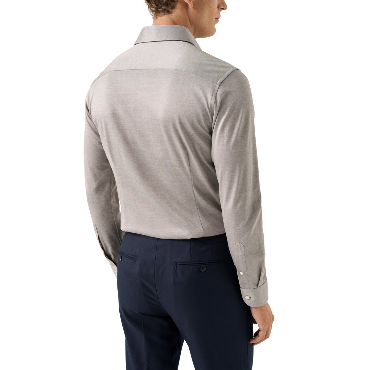 A man shown from the back wearing a light grey long-sleeve button-down shirt and navy blue trousers, photographed against a plain white background. Eton Shirt available at Sakks Menswear in Southampton.