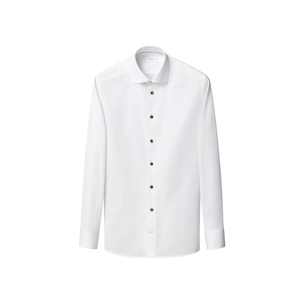 White shirt with burgundy coloured buttons sitting in front of a crisp white background. Eton shirt available at Sakks Menswear in Southampton.