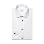 Folded up white shirt with burgundy buttons and detail inside the collar. The tag on the inside of the shirt reads "ETON". The shirt is placed in front of a crisp white background. Eton shirt available at Sakks Menswear in Southampton.