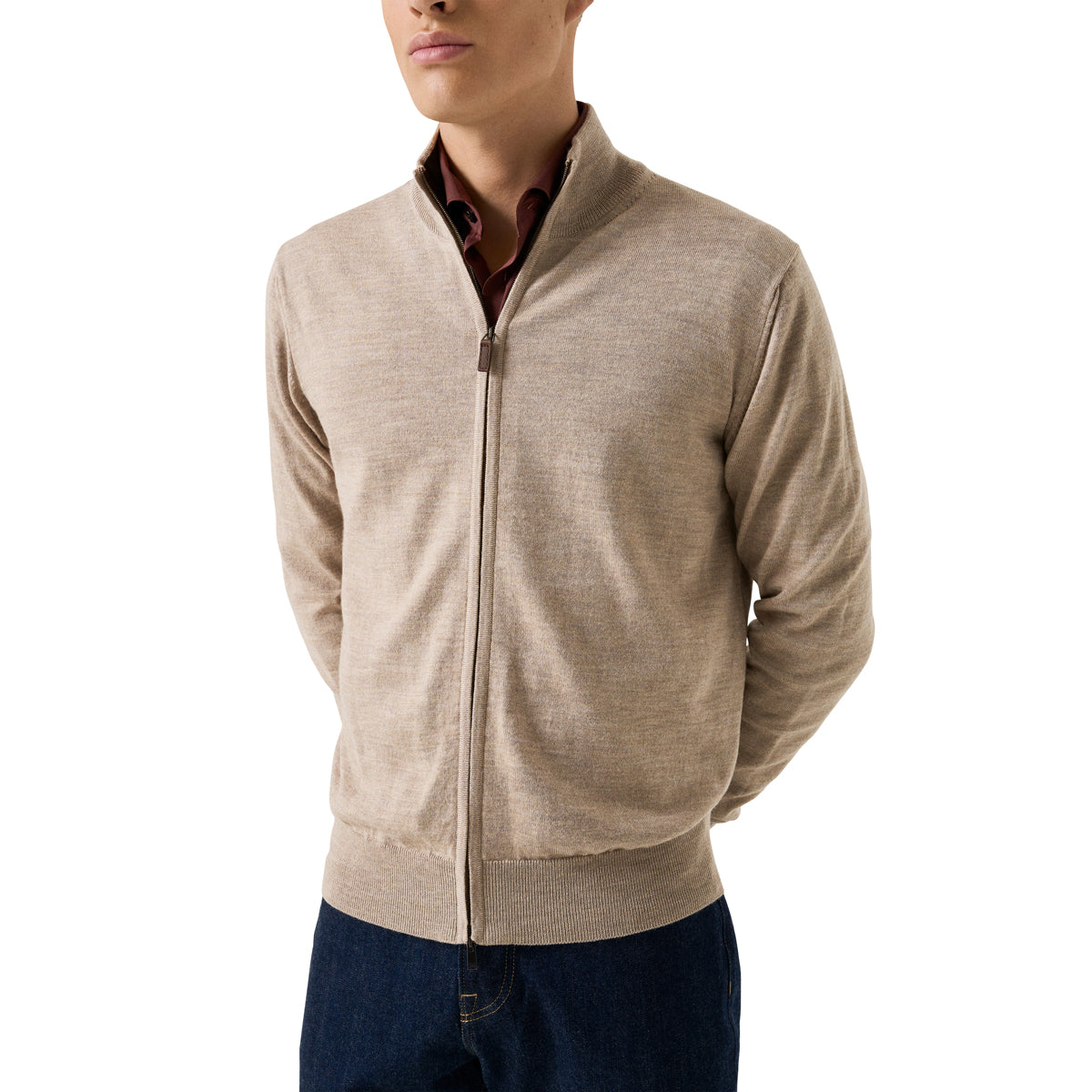A man wearing a light beige zip-up knit cardigan over a dark red collared shirt and dark blue jeans, photographed against a plain white background. Eton Cardigan available at Sakks Menswear in Southampton.