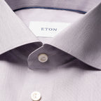 Close-up of a light lavender dress shirt collar with a white button and a visible ETON neck label. Eton Shirt available at Sakks Menswear in Southampton.
