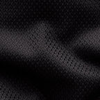 A close-up of a black textured fabric with a subtle woven geometric pattern and soft shadows across the surface. Eton Shirt available at Sakks Menswear in Southampton.