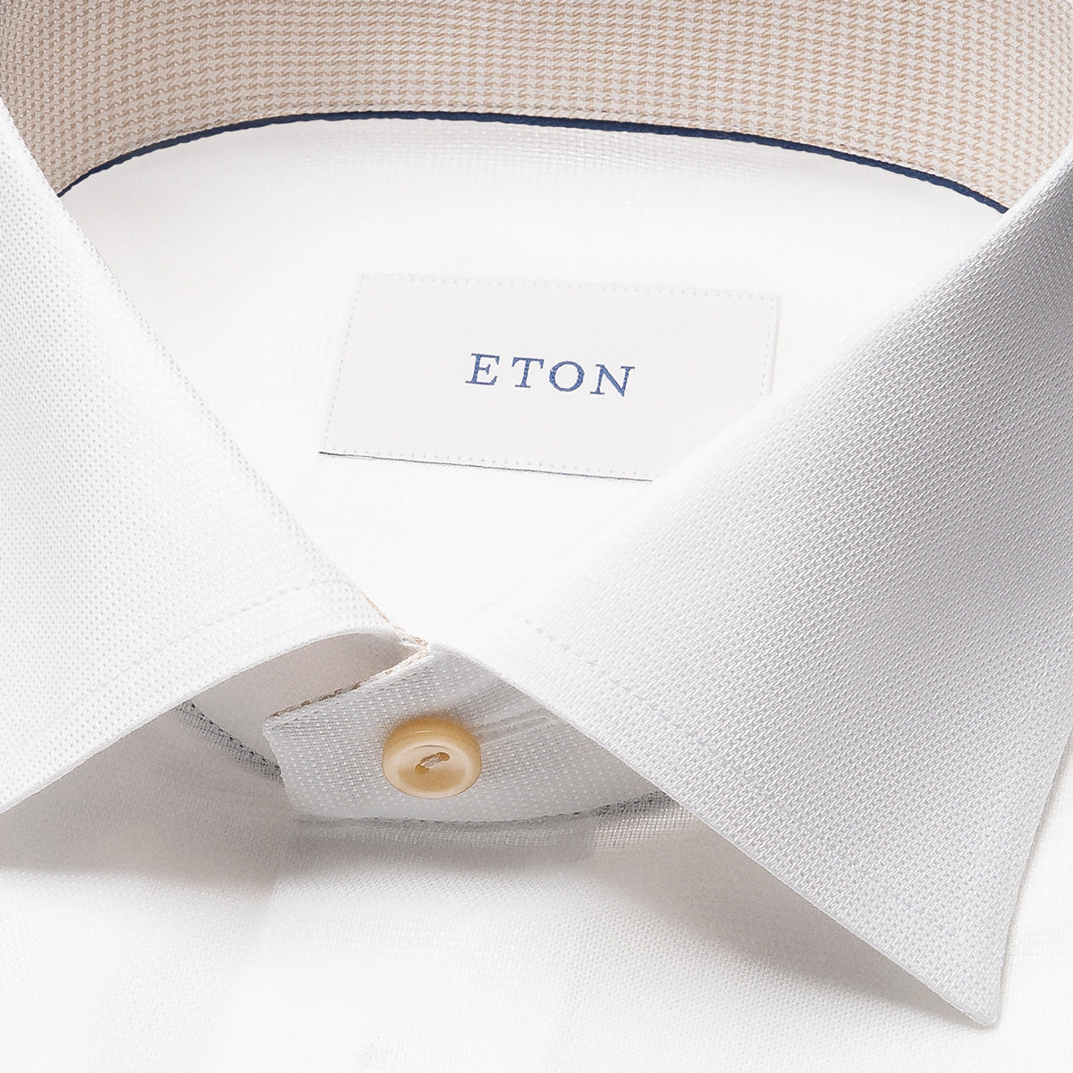 Close-up of a white shirt with a beige collar and 'ETON' label on a white background Eton Shirt available at Sakks Menswear in Southampton.