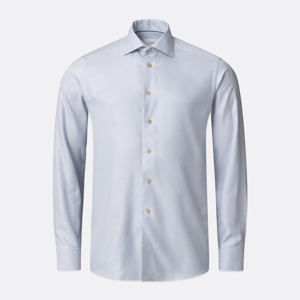 A light blue long-sleeve dress shirt with a classic collar and light-coloured buttons, shown on a clean light grey background. Eton Shirt available at Sakks Menswear in Southampton.