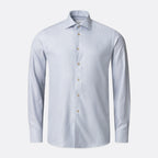 A light blue long-sleeve dress shirt with a classic collar and light-coloured buttons, shown on a clean light grey background. Eton Shirt available at Sakks Menswear in Southampton.