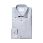 A folded light blue dress shirt with a subtle micro-check pattern, featuring gold buttons and a white neck label with the brand name ETON. Eton Shirt available at Sakks Menswear in Southampton.