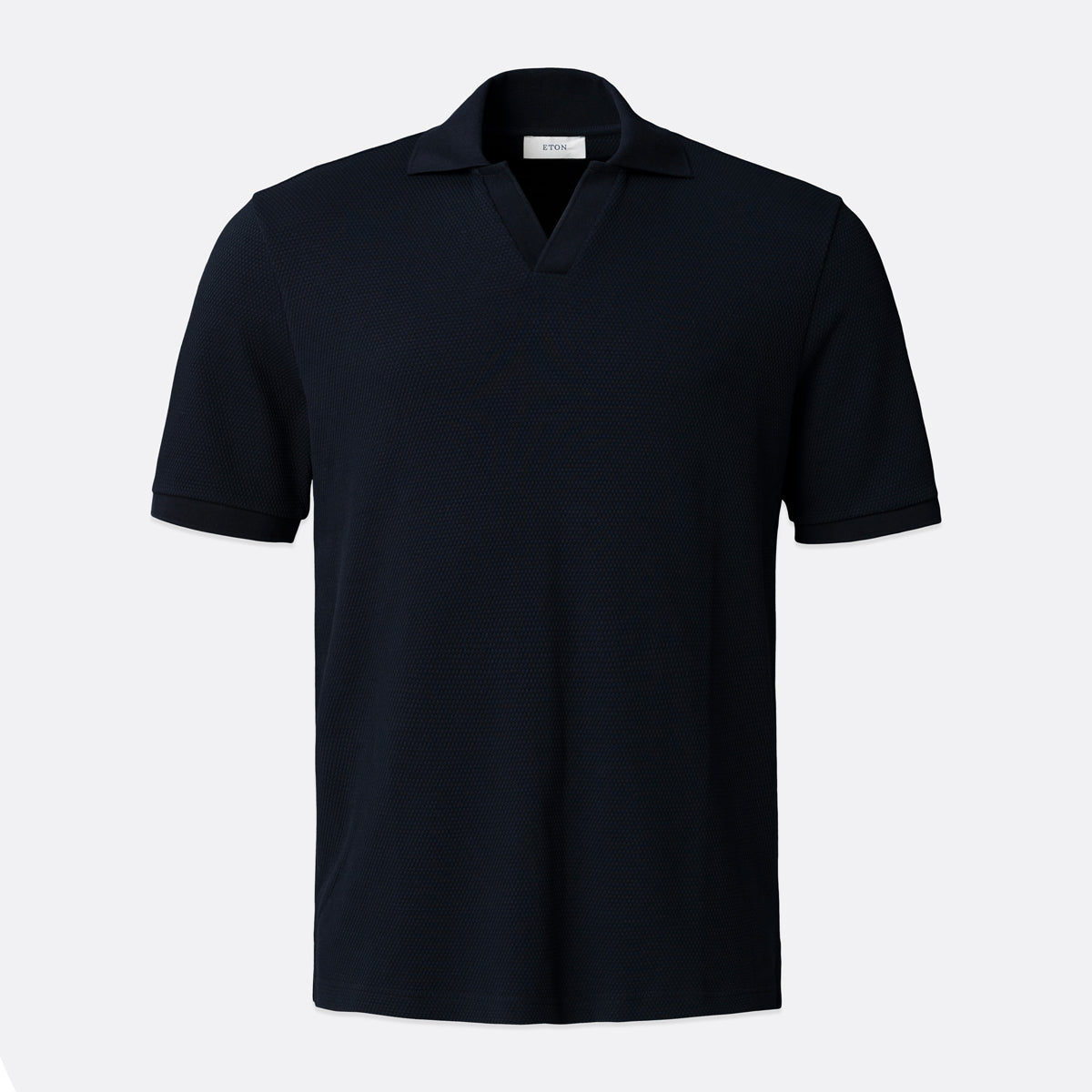 A dark navy blue short-sleeve polo shirt with a classic collar, displayed on a clean, light grey background. Eton Polo available at Sakks Menswear in Southampton.