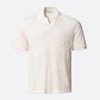 An off-white short-sleeve polo shirt with a textured knit fabric, displayed on a clean, light grey background. Eton Polo available at Sakks Menswear in Southampton.