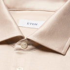 Close-up of a light beige or cream-coloured collared shirt with a visible white neck label reading ETON. Eton Polo Available at Sakks Menswear in Southampton.