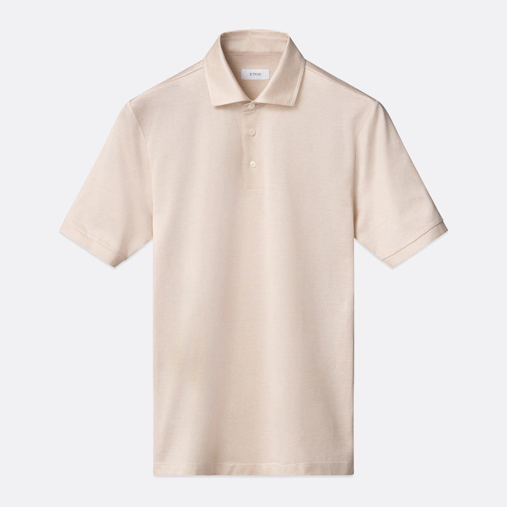 A light beige short-sleeve polo shirt with a classic collar and a two-button placket, displayed flat against a light grey background. Eton Polo Available at Sakks Menswear in Southampton.