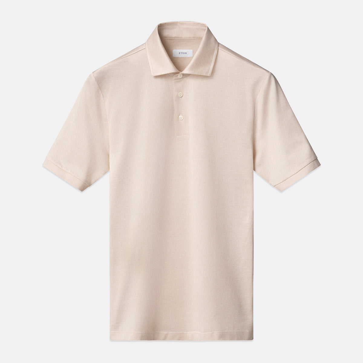 A light beige short-sleeve polo shirt with a classic collar and a two-button placket, displayed flat against a light grey background. Eton Polo Available at Sakks Menswear in Southampton.