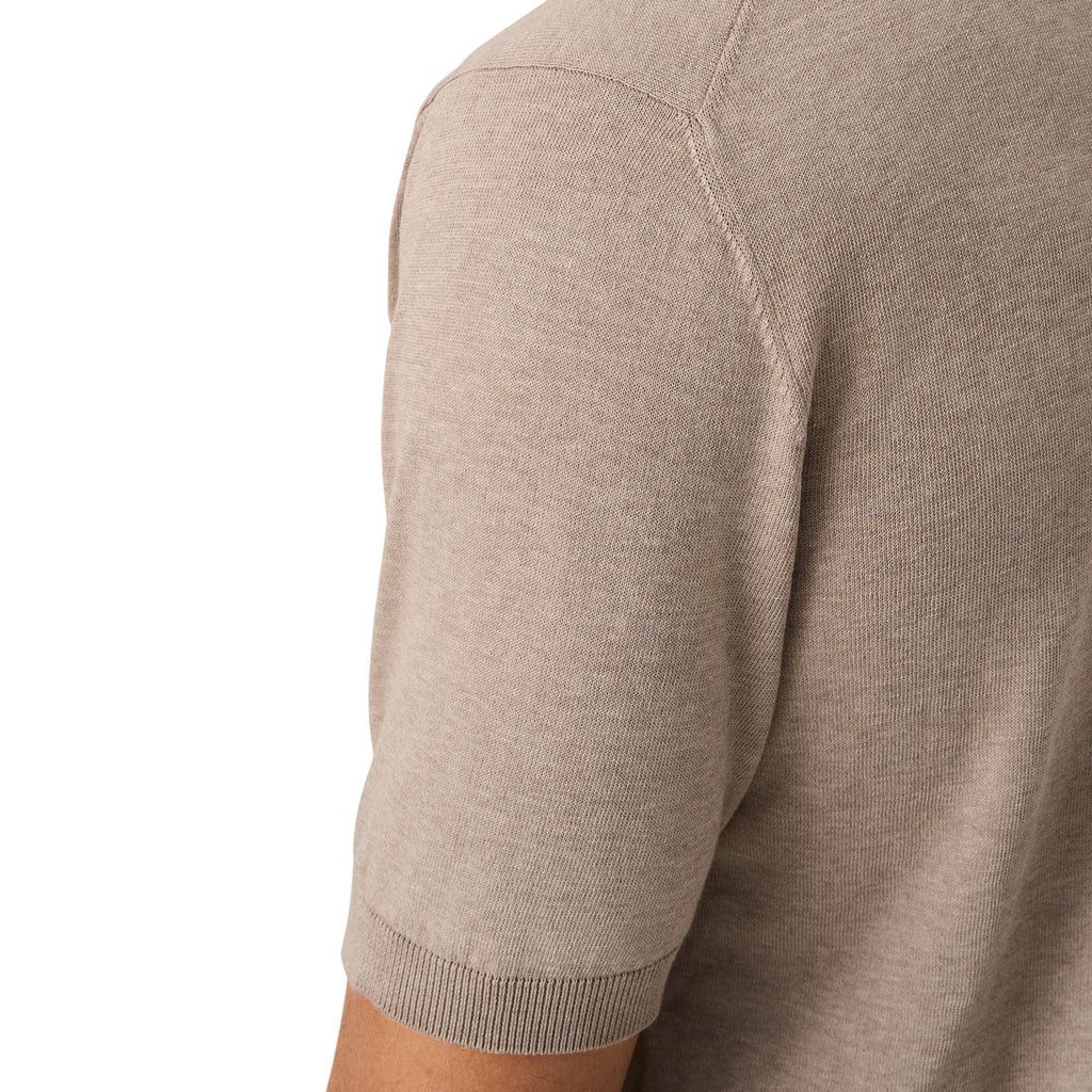 Close-up of a person wearing a short-sleeve knit top in a light taupe-beige color, showing the shoulder seam and ribbed sleeve cuff against a plain white background. Eton Knitted Polo available at Sakks Menswear in Southampton.