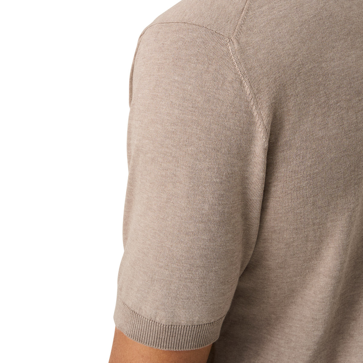 Close-up of a person wearing a short-sleeve knit top in a light taupe-beige color, showing the shoulder seam and ribbed sleeve cuff against a plain white background. Eton Knitted Polo available at Sakks Menswear in Southampton.