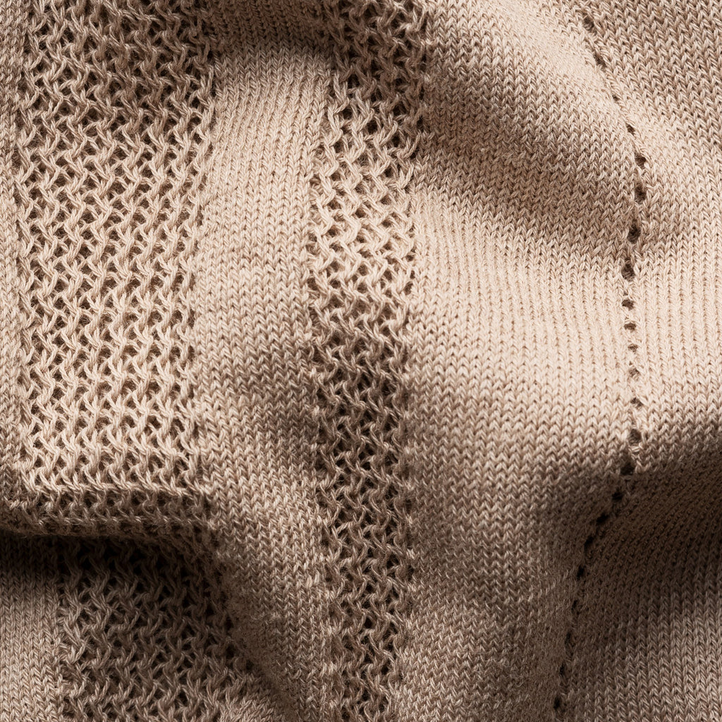 Close-up of a beige knit fabric with textured vertical ribbing and fine mesh-like knit patterns. Eton Knitted Polo available at Sakks Menswear in Southampton.