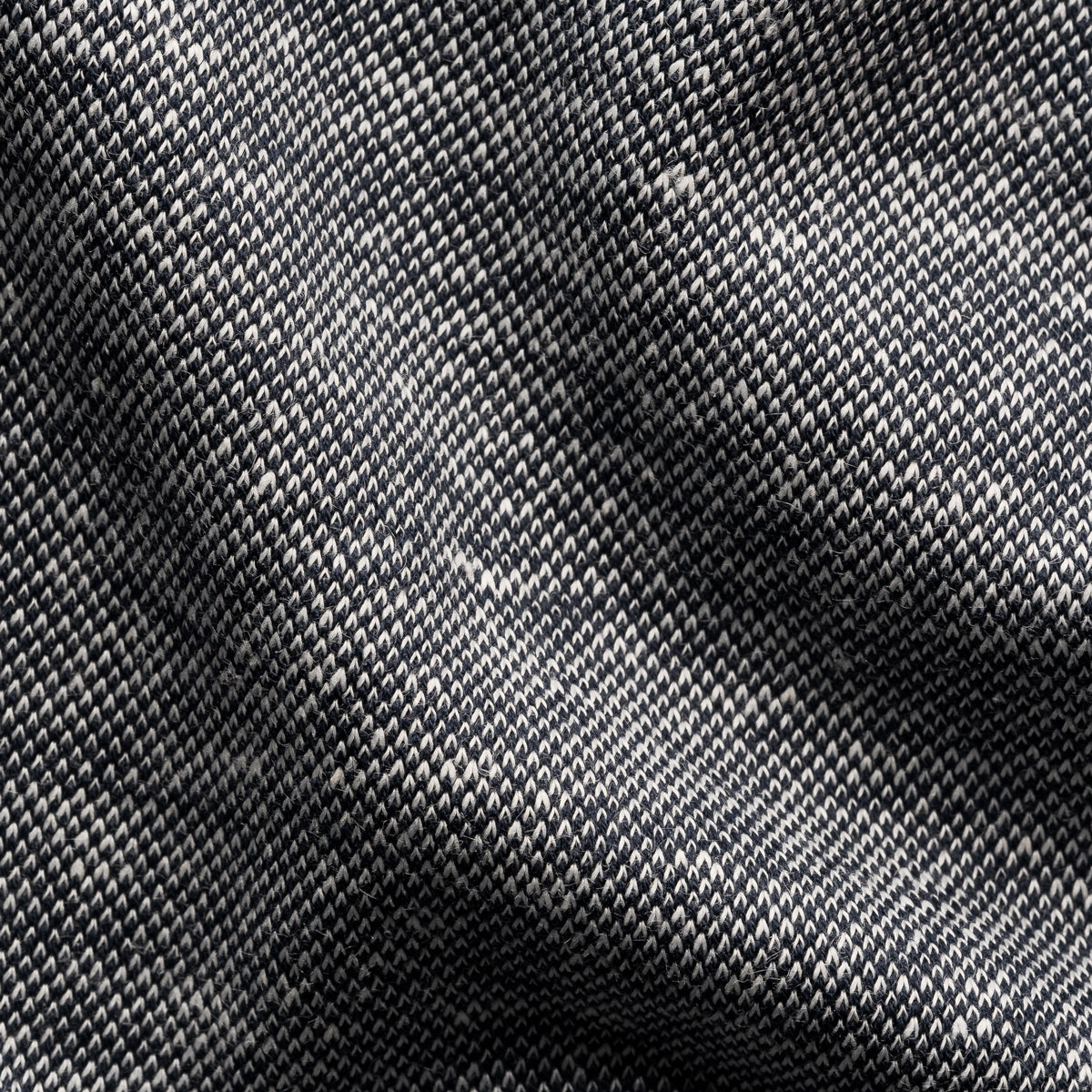 A close-up of a woven fabric texture with a dark grey and black diagonal twill pattern. Eton Polo. Sakks Menswear Southampton.