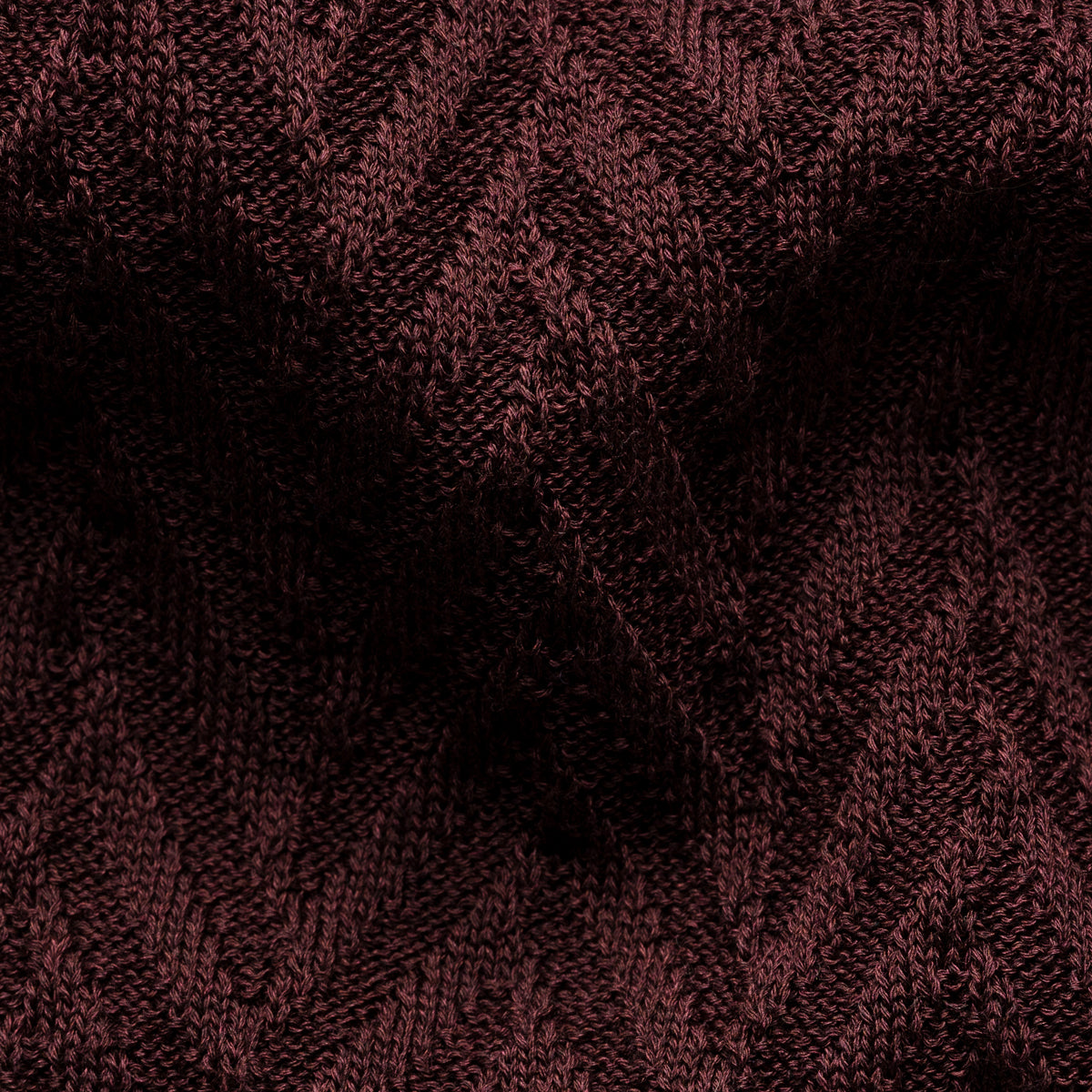 A close-up of a dark burgundy knit fabric with a textured chevron pattern. Eton Polo. Sakks Menswear Southampton.