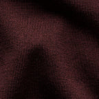 A close-up of a dark burgundy knit fabric texture with soft shadows across the surface. Eton Polo. Sakks Menswear Southampton.