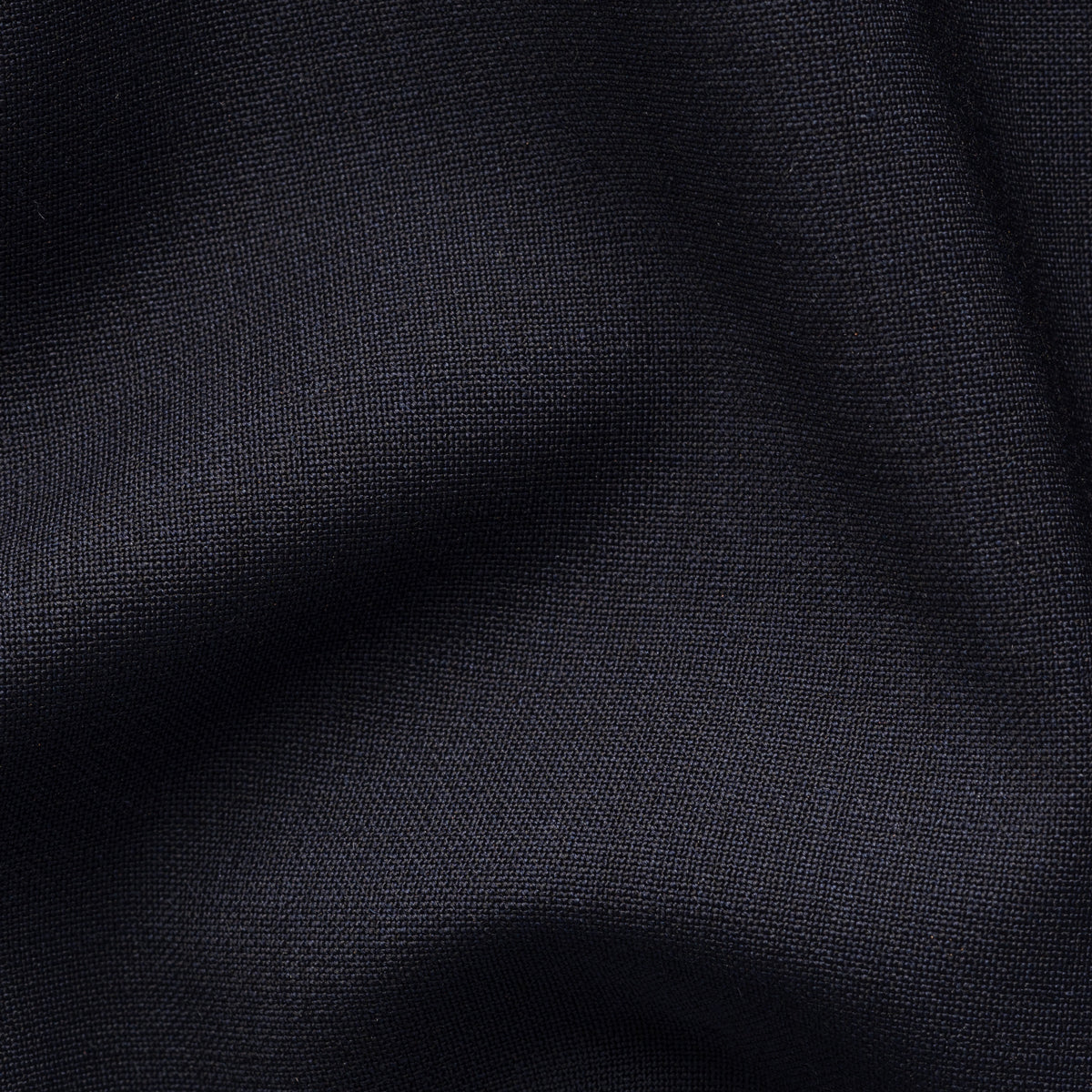 A close-up of dark charcoal gray fabric with soft folds and a fine woven texture. Eton Gilet. Sakks Menswear Southampton.