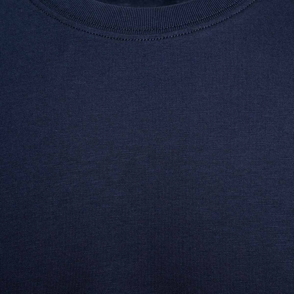 Close-up of a dark navy blue ribbed knit fabric, showing the texture and crew neck collar detail. Eton T-Shirt. Sakks Menswear Southampton.