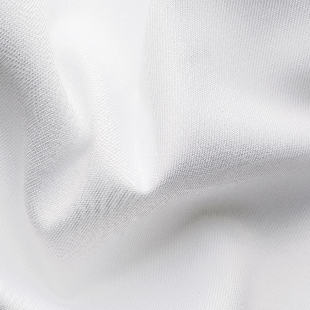 A close-up of white fabric with soft folds and a fine woven texture filling the frame. Eton Dinner Shirt. Sakks Menswear Southampton.