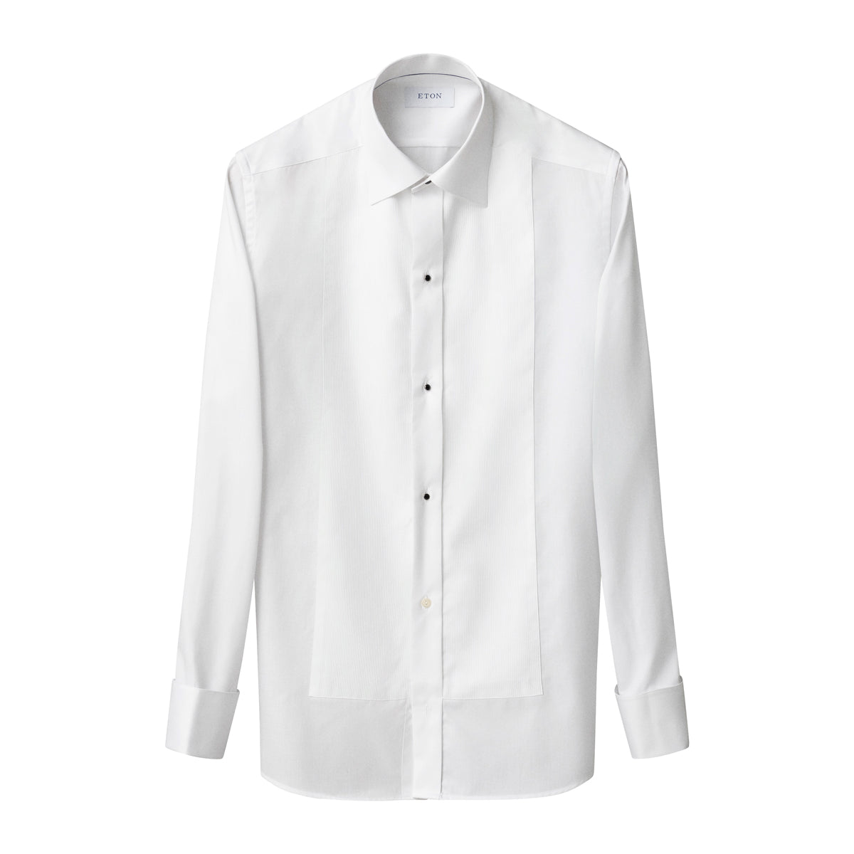 A white long-sleeve button-up shirt with a pointed collar, black buttons, and front pleat details, shown on a plain white background. Eton Dinner Shirt. Sakks Menswear Southampton.