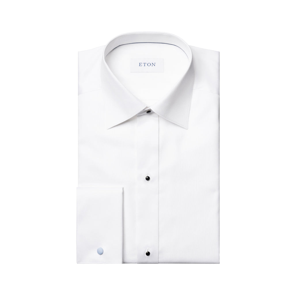 A folded white long-sleeve dress shirt with a pointed collar, button-down front, and a single-button cuff, shown on a plain white background. The brand name 'ETON' is visible on the inner neck label. Eton Dinner Shirt. Sakks Menswear Southampton.