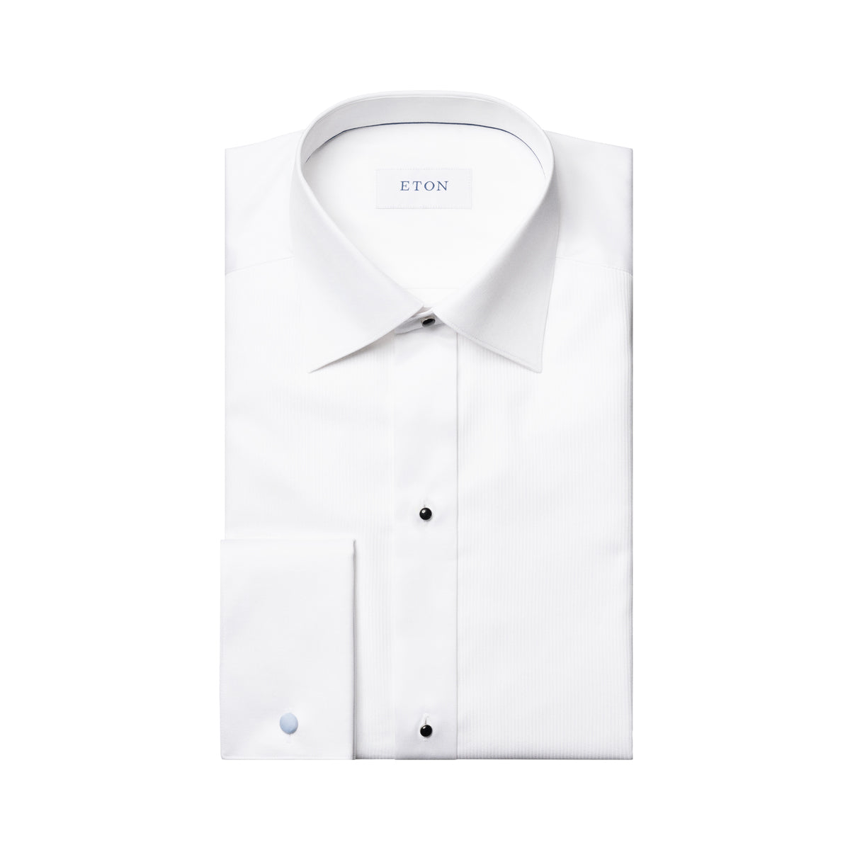 A folded white long-sleeve dress shirt with a pointed collar, button-down front, and a single-button cuff, shown on a plain white background. The brand name 'ETON' is visible on the inner neck label. Eton Dinner Shirt. Sakks Menswear Southampton.