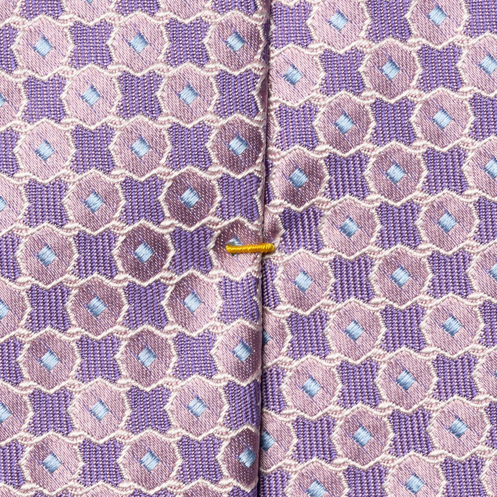 Close-up of a patterned necktie with a purple and pink geometric design, light blue diamond accents, and a thin gold center stripe. Eton Ties available at Sakks Menswear in Southampton.