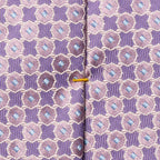 Close-up of a patterned necktie with a purple and pink geometric design, light blue diamond accents, and a thin gold center stripe. Eton Ties available at Sakks Menswear in Southampton.