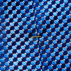 Close-up of a textured woven necktie fabric with a repeating geometric pattern of light and medium blue circles, dark navy hexagons, and thin red lines, featuring a small yellow tie clip on the front. Eton Ties available at Sakks Menswear in Southampton.