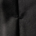 Close-up of a black textured fabric with a central vertical seam and a small stitched detail near the middle. Eton Ties available at Sakks Menswear in Southampton.