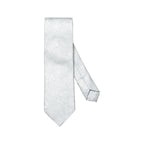 A light silver necktie with a subtle woven paisley pattern, displayed on a clean white background. Eton Ties available at Sakks Menswear in Southampton.