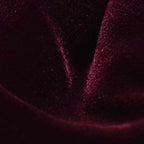 A close-up of dark plum velvet fabric with a soft sheen and visible fine texture. Eton Bow Tie available at Sakks Menswear in Southampton.