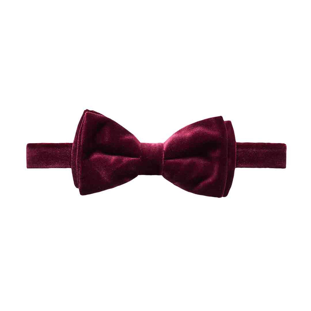 A pre-tied bow tie and matching elastic headband in a deep burgundy velvet fabric, shown against a plain white background. Eton Bow Tie available at Sakks Menswear in Southampton.