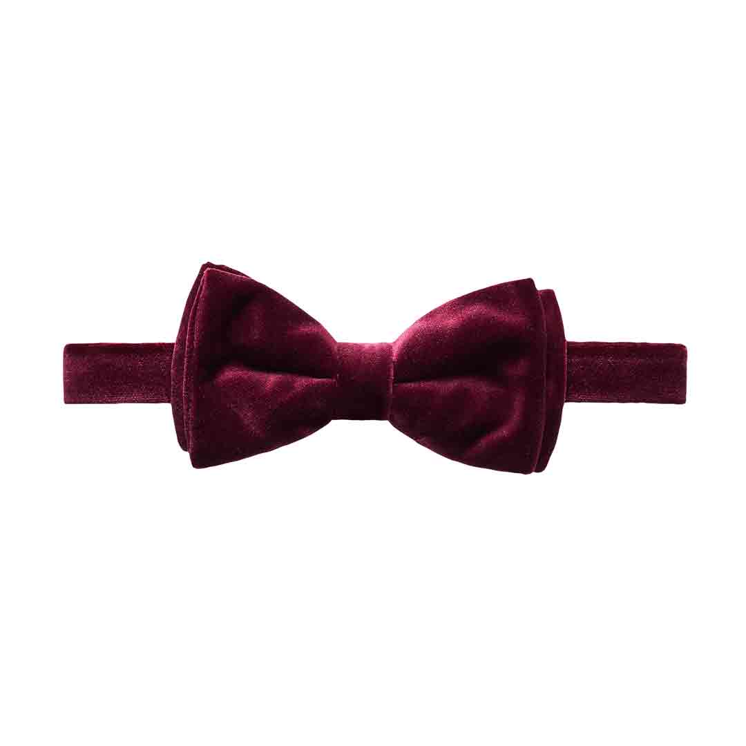 A pre-tied bow tie and matching elastic headband in a deep burgundy velvet fabric, shown against a plain white background. Eton Bow Tie available at Sakks Menswear in Southampton.