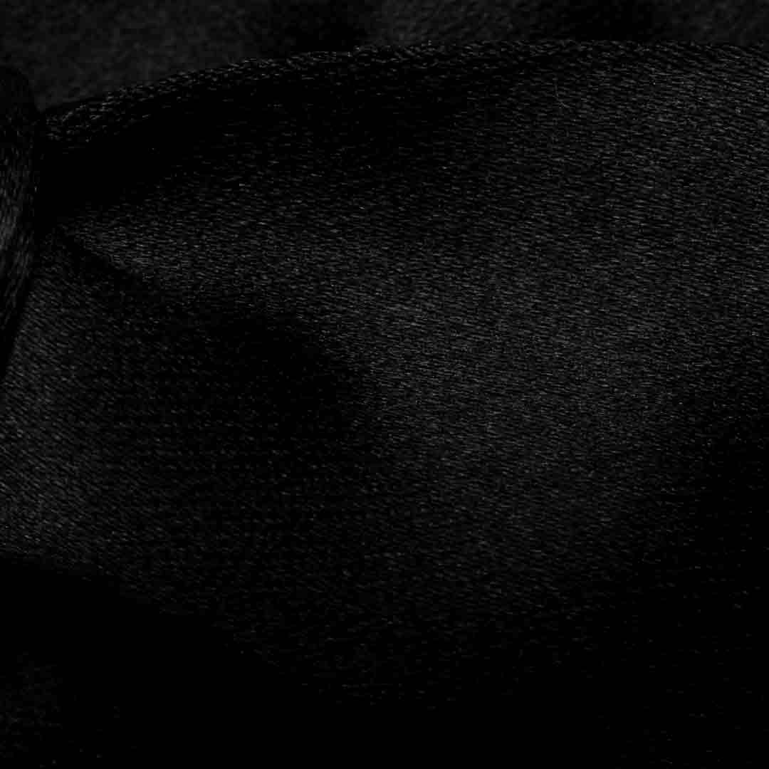 A close-up of black textured fabric with a fine woven pattern and soft folds. Eton Bow Ties available at Sakks Menswear in Southampton.