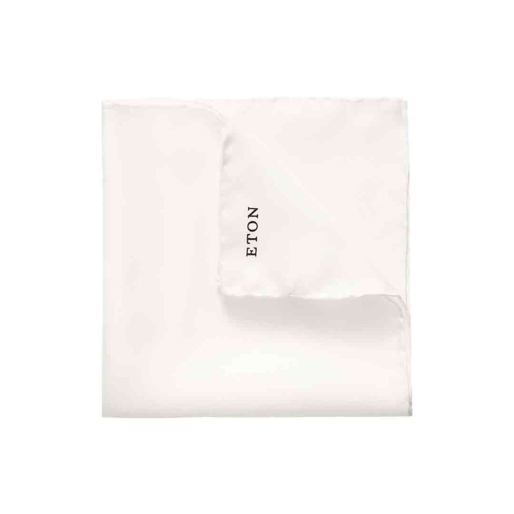A folded white pocket square with the brand name 'ETON' printed in black on one corner, set against a plain white background. Eton Pocket Square available at Sakks Menswear in Southampton.