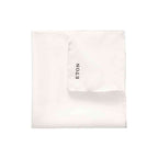 A folded white pocket square with the brand name 'ETON' printed in black on one corner, set against a plain white background. Eton Pocket Square available at Sakks Menswear in Southampton.