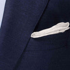 Close-up of a navy blue textured suit jacket with a white pocket square tucked into the breast pocket. Eton Pocket Square available at Sakks Menswear in Southampton.